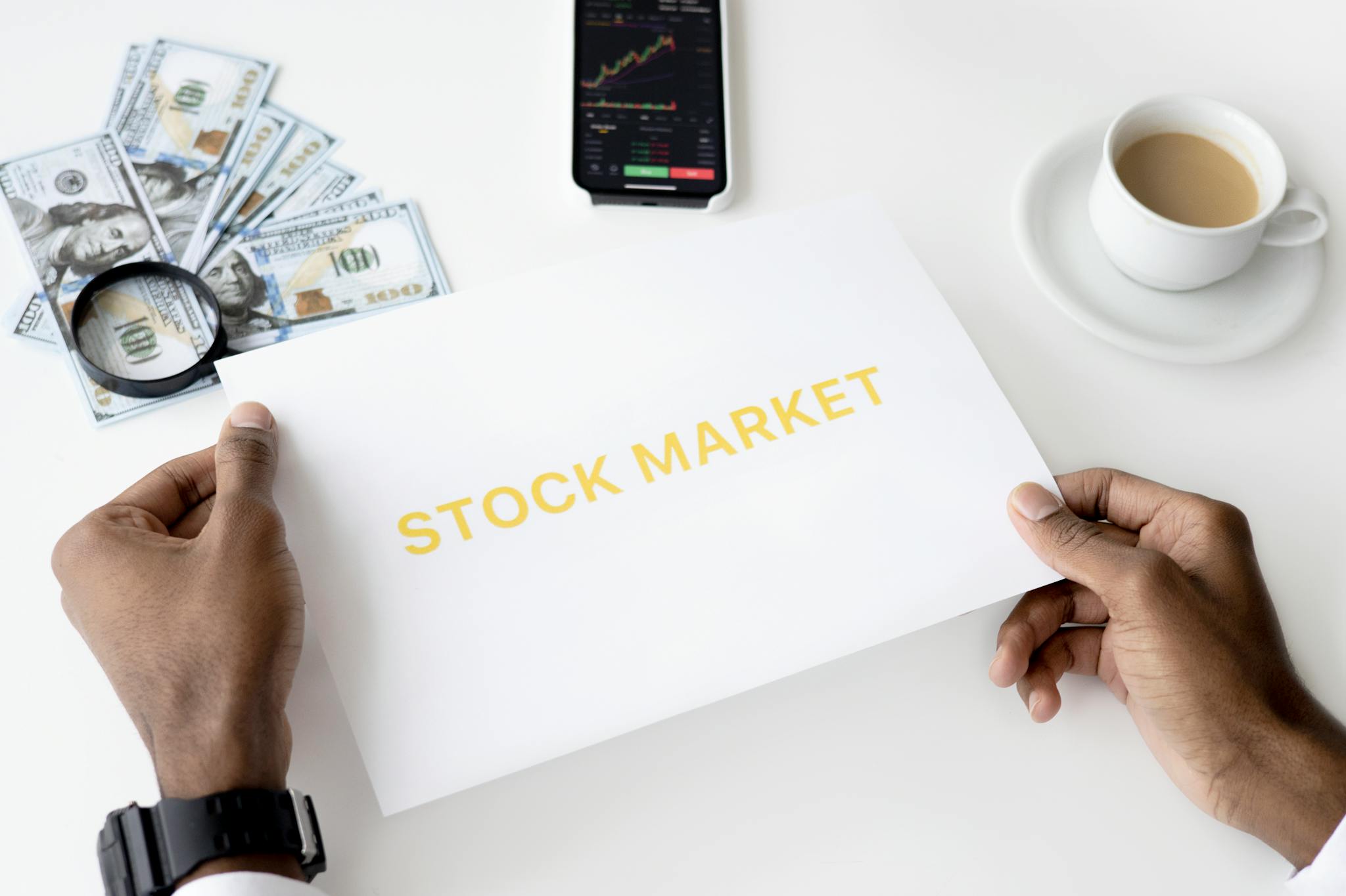 Business theme with stock market document, currency, and mobile display.